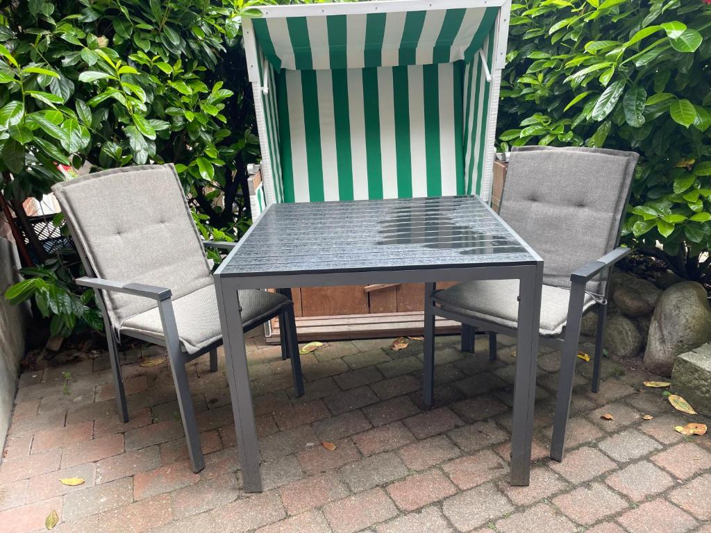 un tavolo verde e 2 sedie su un patio di Luv a Oevenum