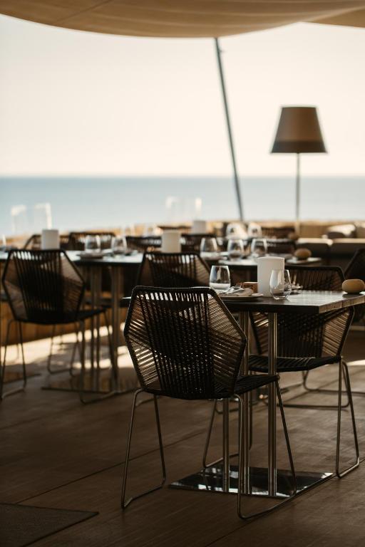 a group of tables and chairs in a restaurant at 7Pines Resort Ibiza, part of Destination by Hyatt in San Jose