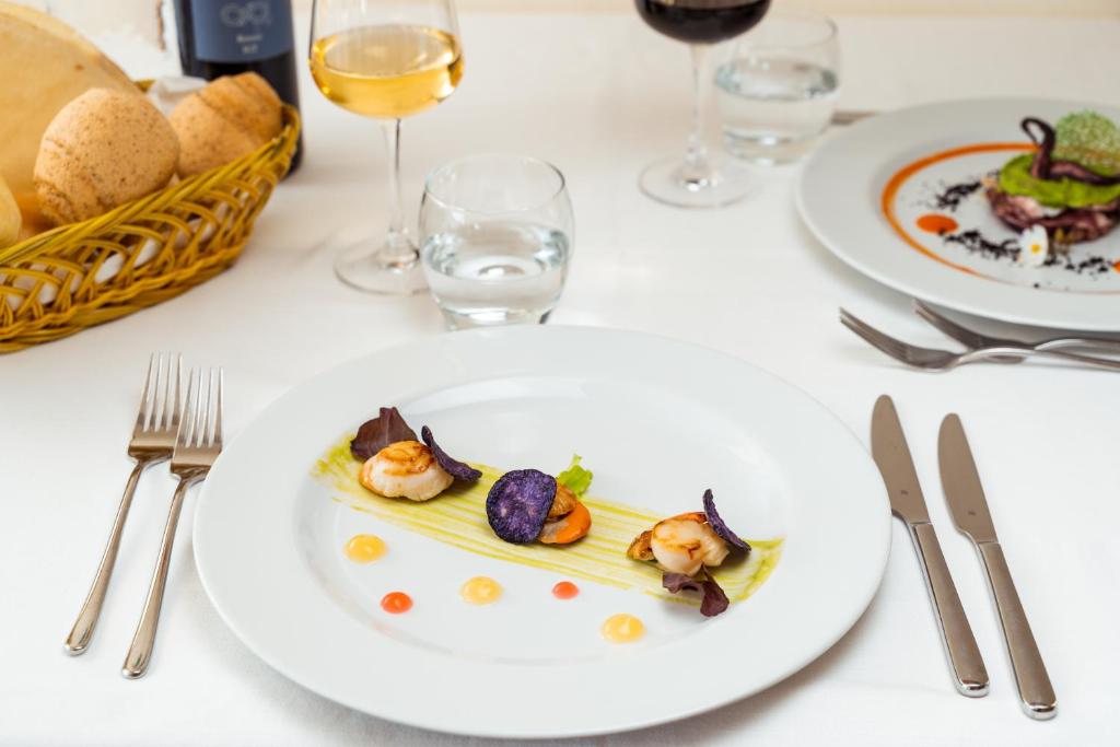 a table with plates of food and glasses of wine at Hotel dP Olbia - Sardinia in Olbia
