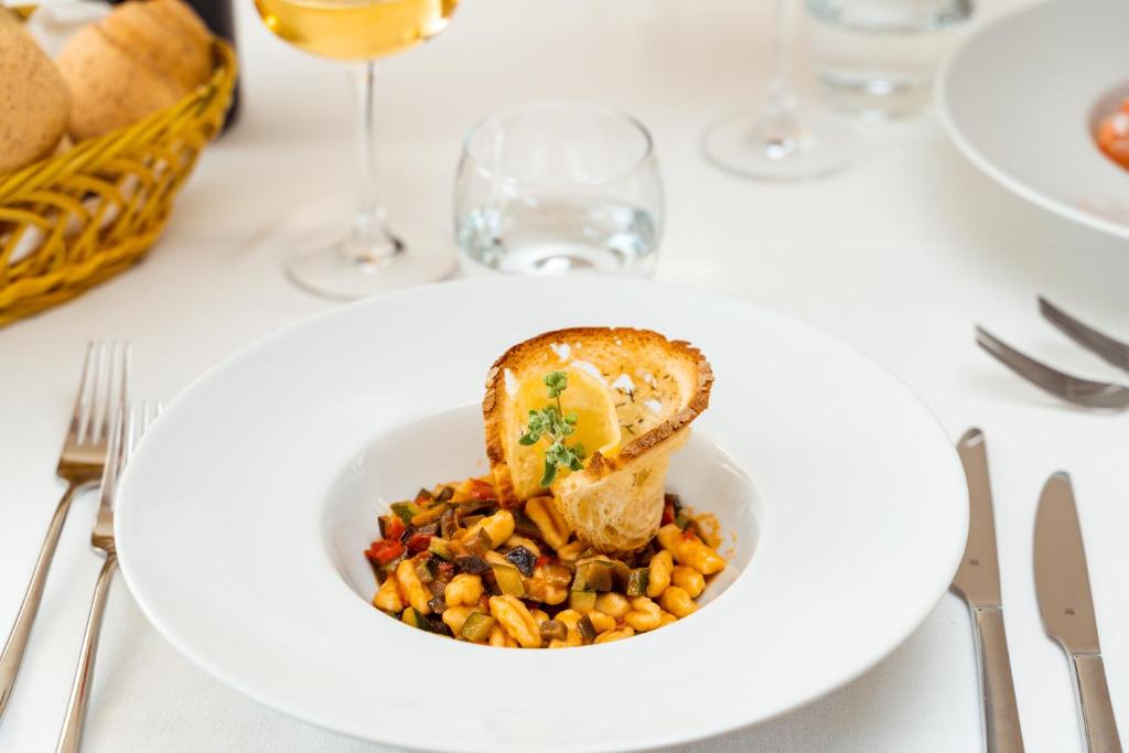 a plate of food with corn and bread on a table at Hotel dP Olbia - Sardinia in Olbia