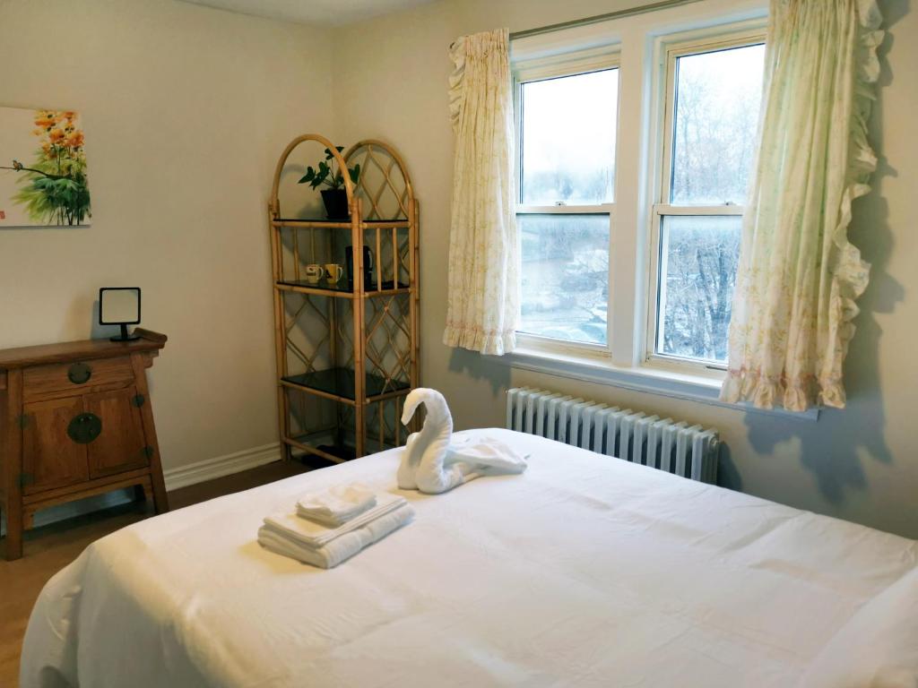 Un dormitorio con una cama con toallas y un cisne. en Cozy Private Rm Heart of North York Free Parking Full Kitchen Close to Downtown en Toronto