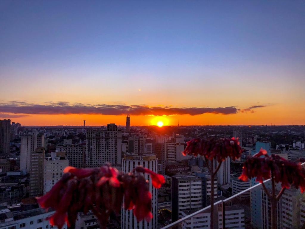 une vue du coucher de soleil depuis le haut d'un immeuble dans l'établissement Apto central, com vista deslumbrante!, à Curitiba