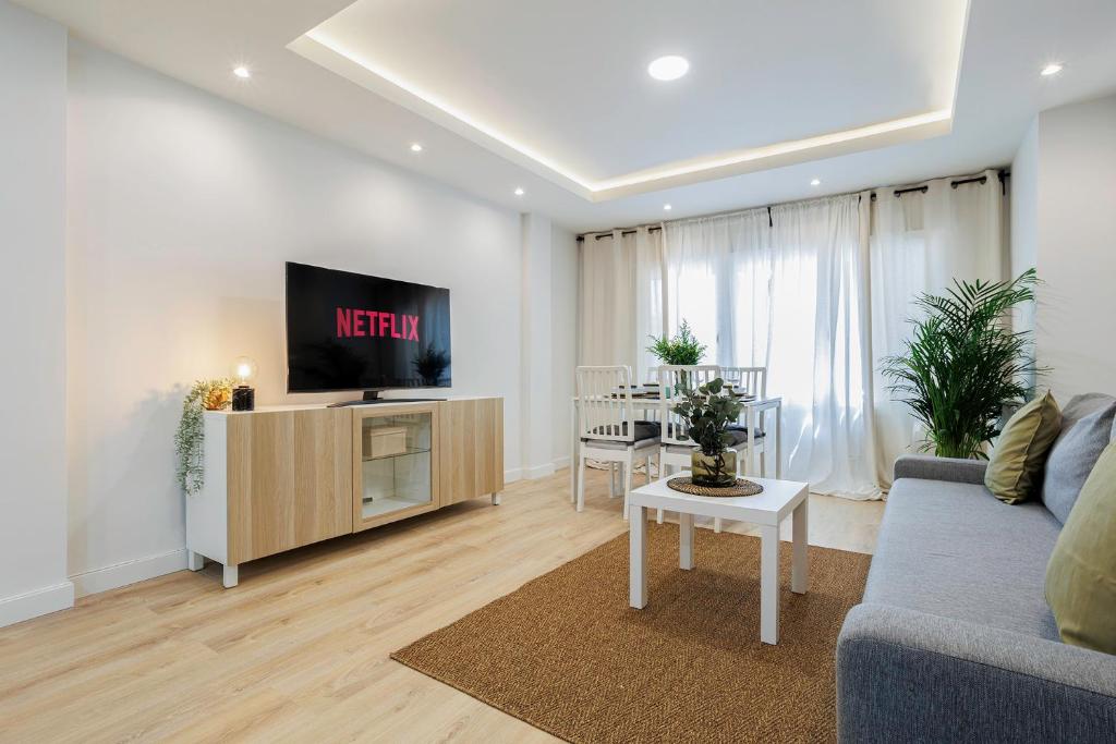 a living room with a couch and a tv and a table at GENESIS APARTMENT IN MADRID in Madrid