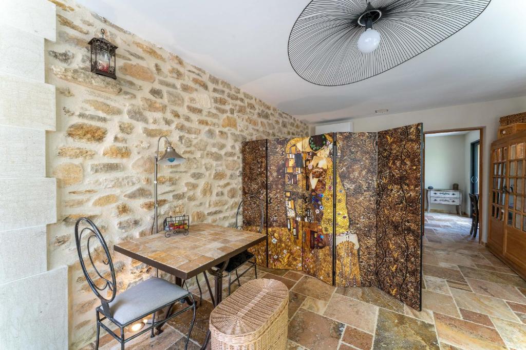 une salle à manger avec une table et un mur en pierre dans l'établissement Villa La Mireio, à Malaucène