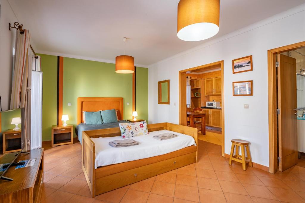 1 dormitorio con 1 cama y 1 habitación con TV en Apartamentos Pátio Victória by Umbral en Vila Nova de Milfontes