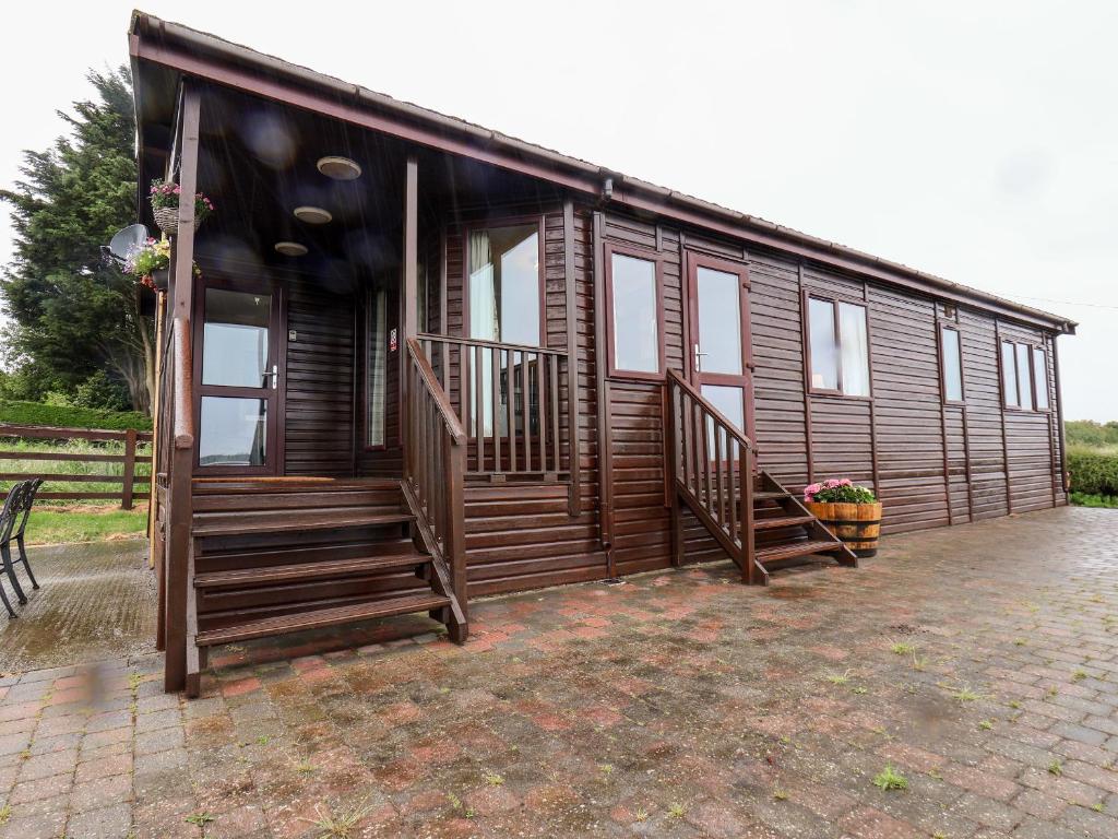 a large wooden cabin with stairs and a porch at Handale Banks Farm Lodge in Saltburn-by-the-Sea