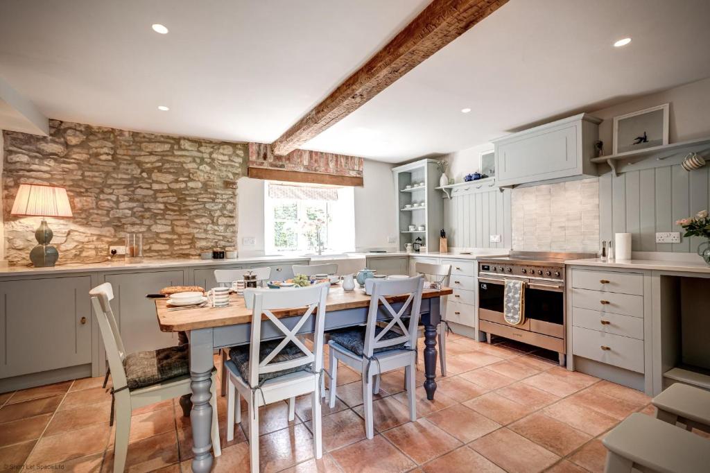 a large kitchen with a wooden table and chairs at Hutts Bothy in Oxford