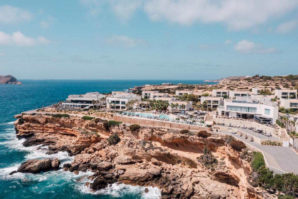 Blick auf ein Resort auf einer Klippe am Meer in der Unterkunft 7Pines Resort Ibiza, part of Destination by Hyatt in San Jose