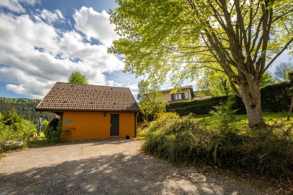 a small yellow house with a tree next to it at Chalet Le Pin in Xonrupt-Longemer