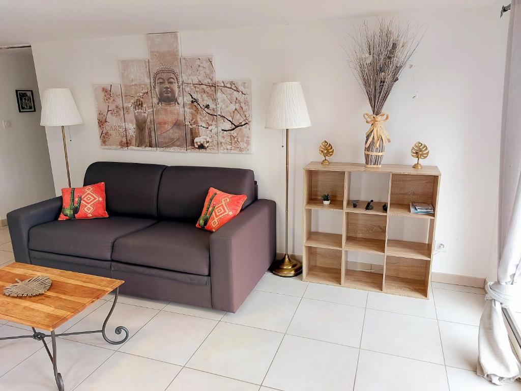 uma sala de estar com um sofá e uma mesa em MONTALIEU SEJOUR Rez de jardin Les jonquilles - 1 à 4 PERS - PROX CNPE BUGEY - VALLEE BLEU - VIA RHONA em Montalieu-Vercieu