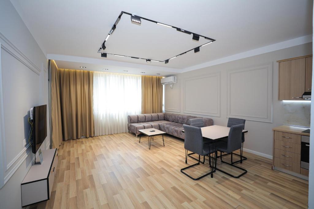 ein Wohnzimmer mit einem Sofa, einem Tisch und Stühlen in der Unterkunft Miku Apartment -Outstanding Apartment at Taiwan in Tirana