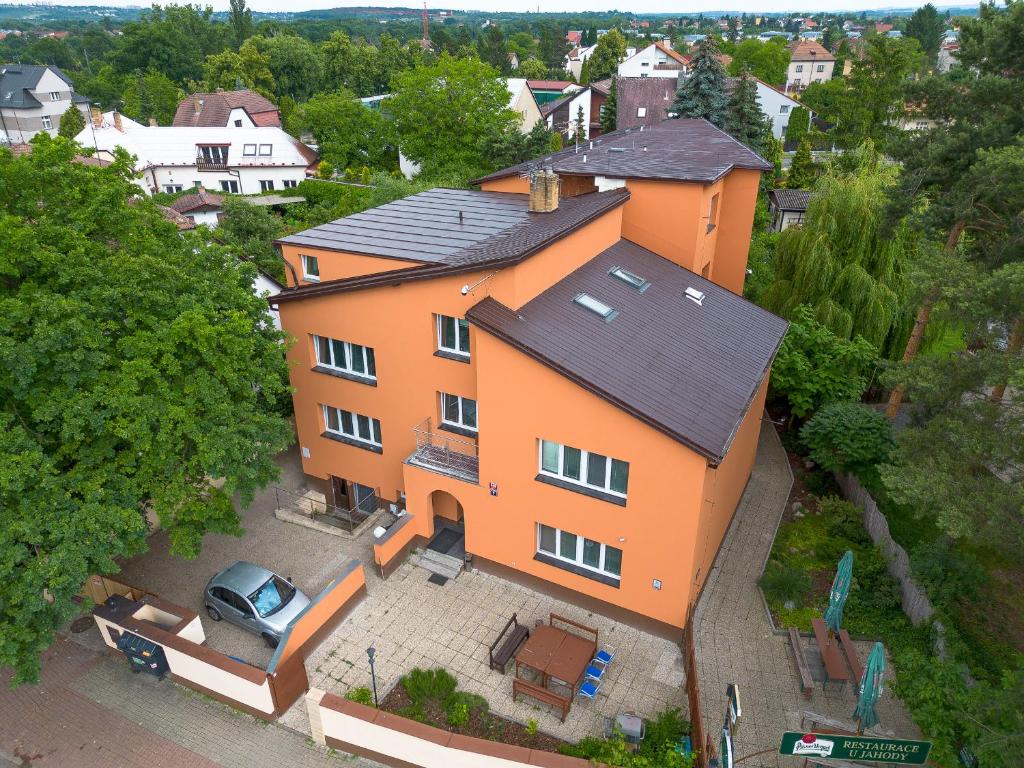 een oranje huis met een auto ervoor bij Hotel Max in Praag