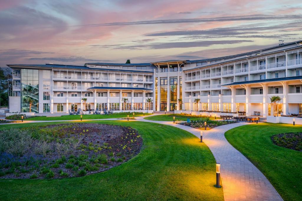 un grand bâtiment avec une pelouse devant lui dans l'établissement Mövenpick Balaland Resort Lake Balaton, à Szántód