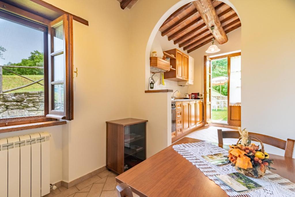 uma cozinha e sala de jantar com uma mesa e uma janela em Pugnano Alto - appartamento Grano em Lisciano Niccone
