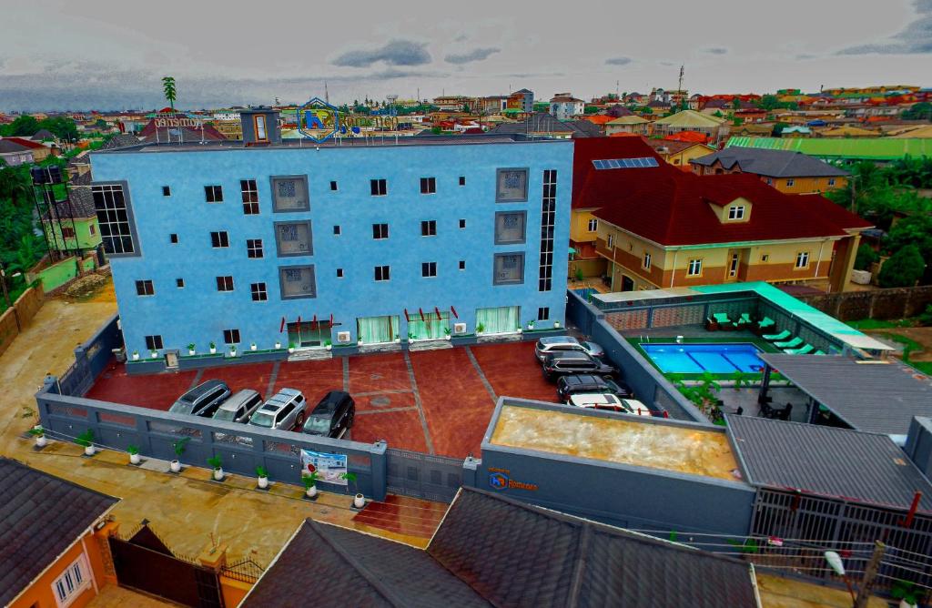 un gran edificio azul con aparcamiento y piscina en HOTEL ROMENEO en Lagos