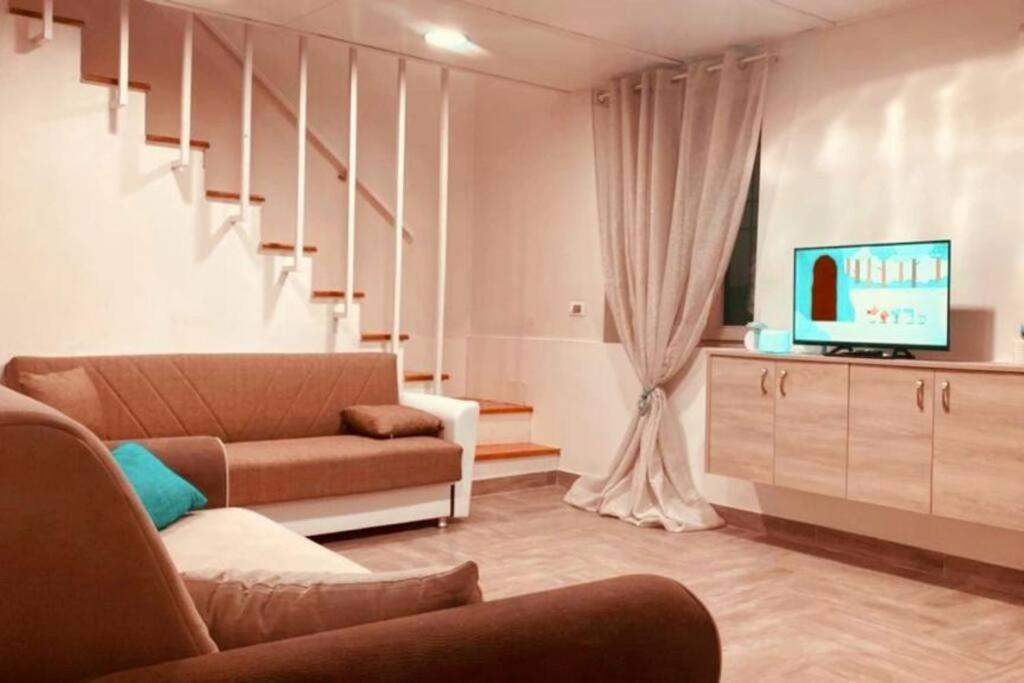 sala de estar con sofá y TV en Casa Vacanze Aversa centro, en Aversa