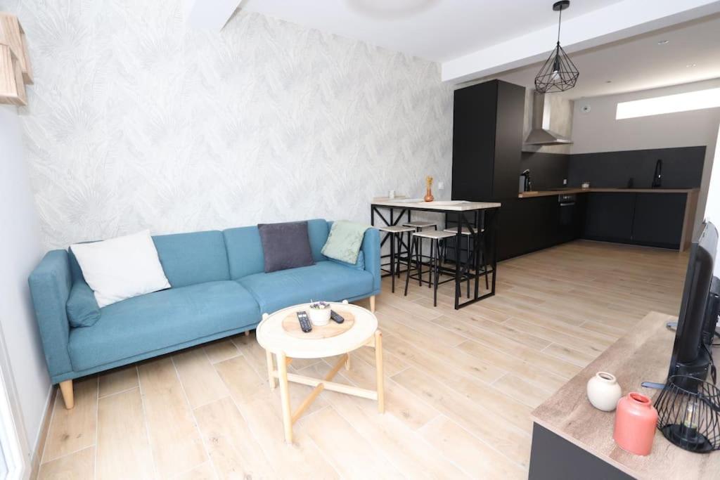 un salon avec un canapé bleu et une table dans l'établissement Maison Charme & Mer à Dunkerque, à Dunkerque