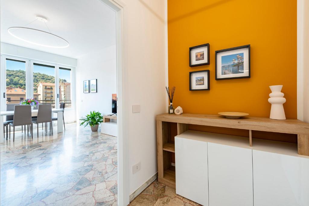 a kitchen with orange walls and a dining room at Labiena Lake Maggiore in Laveno-Mombello