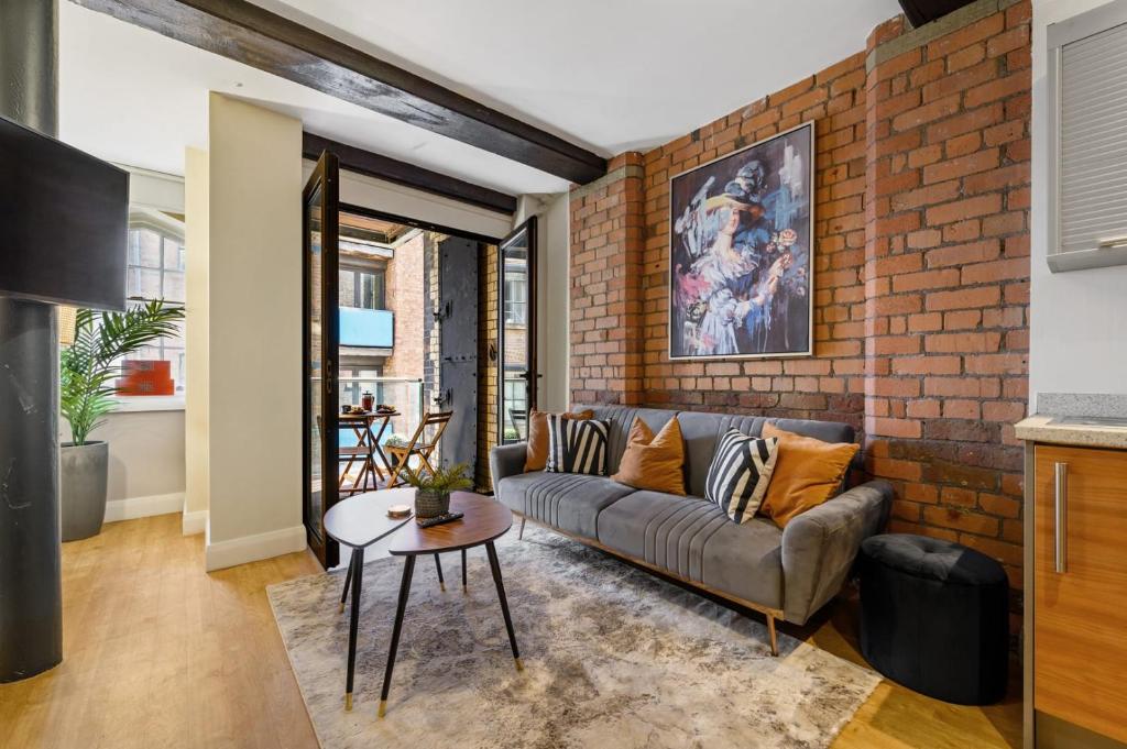 un soggiorno con divano e muro di mattoni di Host & Stay - Queen Square Apartment a Liverpool