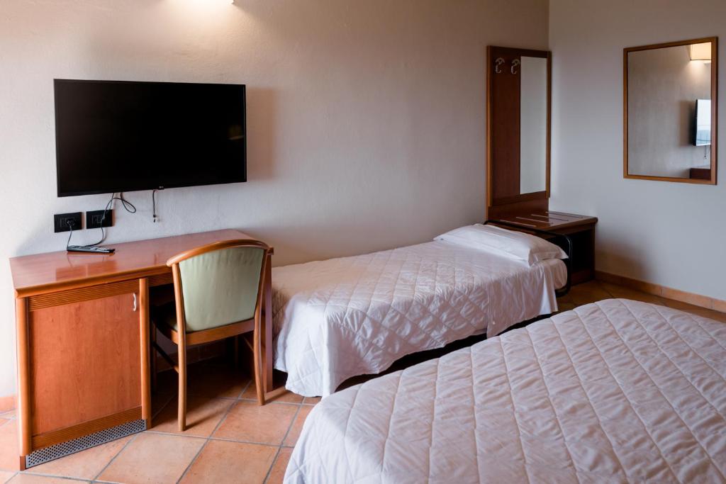 A bed or beds in a room at Hotel La Scottiglia e Ristorante