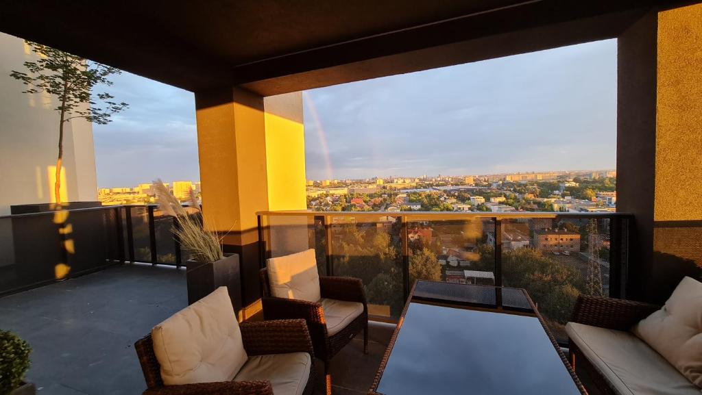 a balcony with chairs and a view of a city at Widokowy Apartament Wojciechowskiego Parking i Loggia by Renters Prestige in Poznań