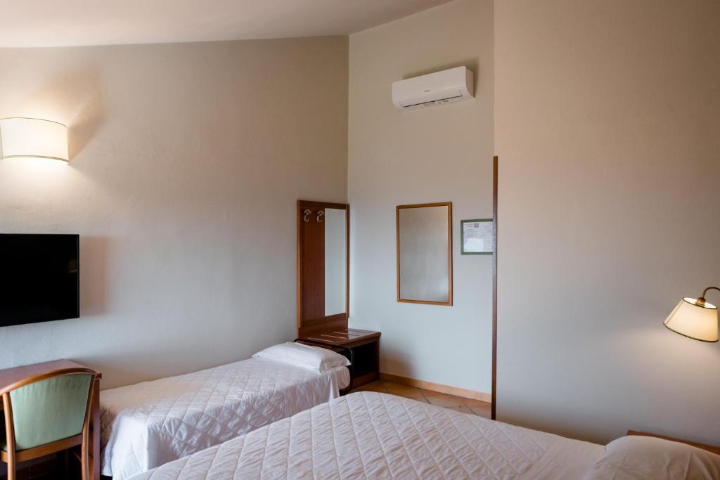 A bed or beds in a room at Hotel La Scottiglia e Ristorante