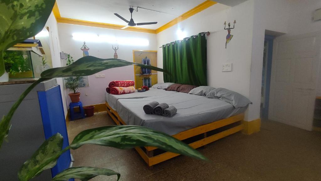 - une chambre avec un lit et un rideau vert dans l'établissement ADH Amilia Gardens, à Mysore