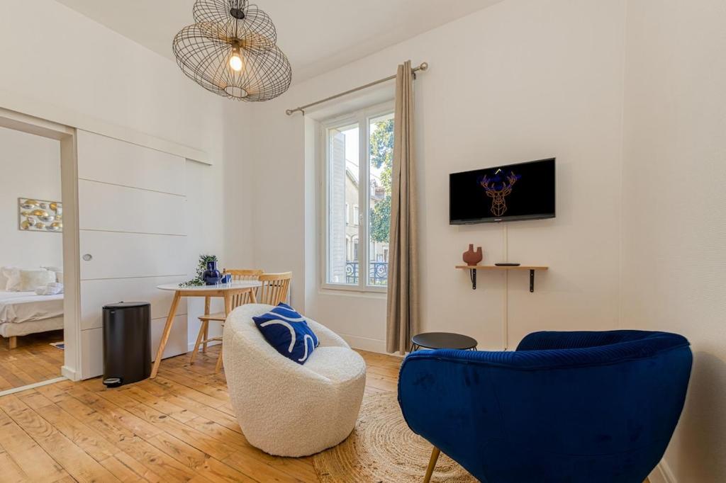 a living room with blue chairs and a table at 2 pièces tout confort, déco moderne, wifi fibre in Grenoble