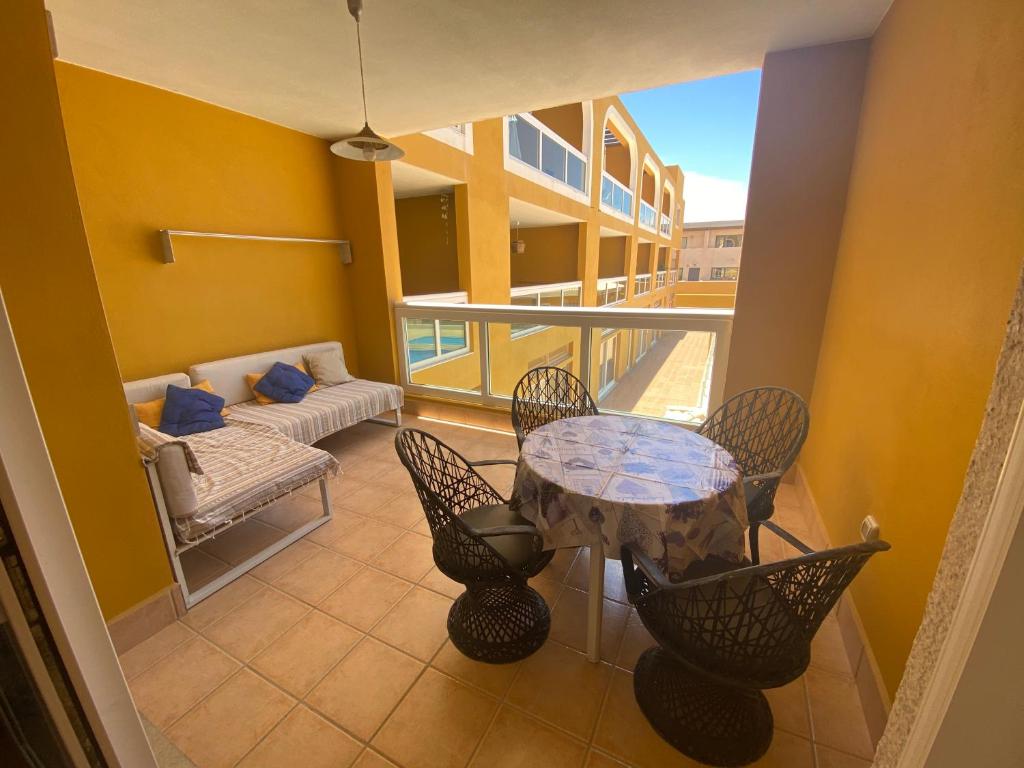 a balcony with a table and chairs and a couch at Vida Cotillo - No Stress Holidays in El Cotillo