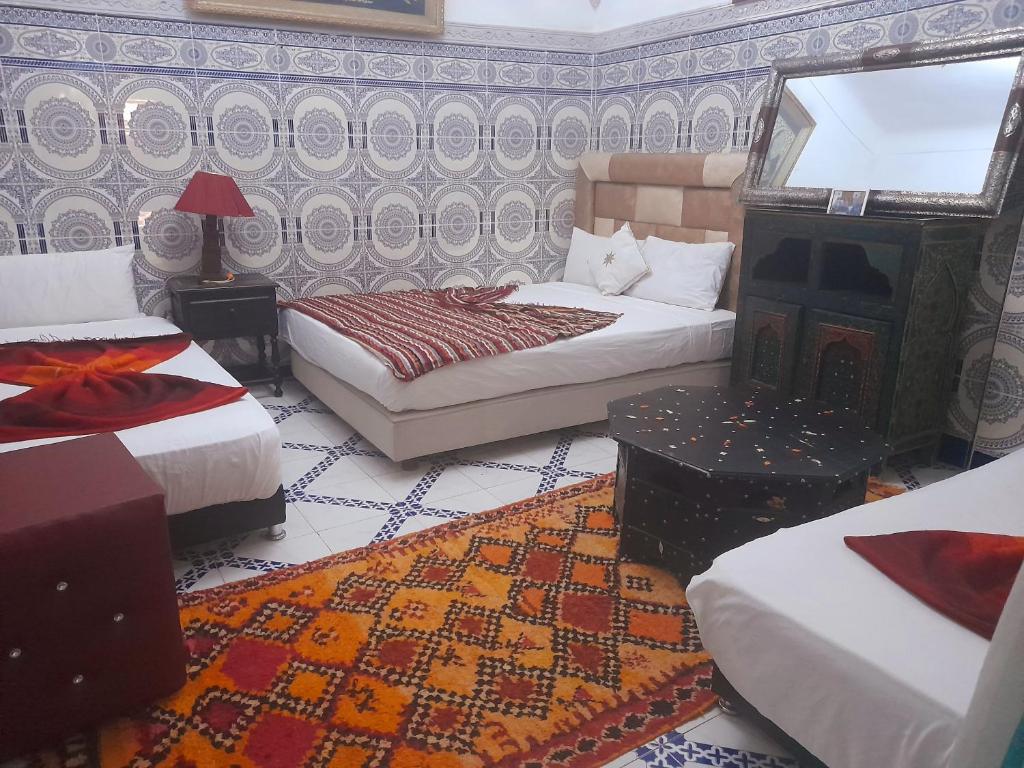 a hotel room with two beds and a fireplace at Riad Chennaoui in Marrakech