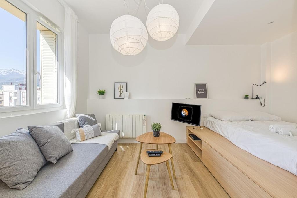 - un salon blanc avec un lit et un canapé dans l'établissement Joli appartement - wifi - Vallier Catane, à Grenoble