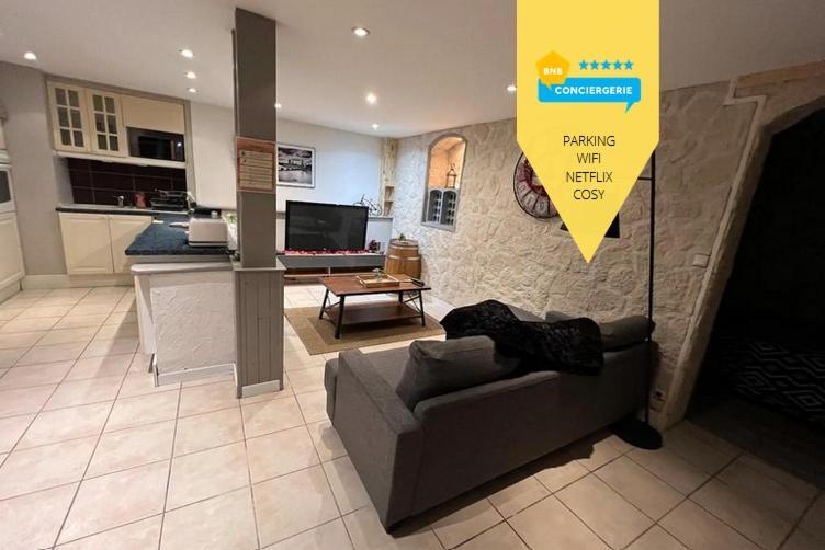 un salon avec un canapé et une cuisine dans l'établissement Les 4 chênes - T2 refait à neuf, à Le Pont-de-Beauvoisin