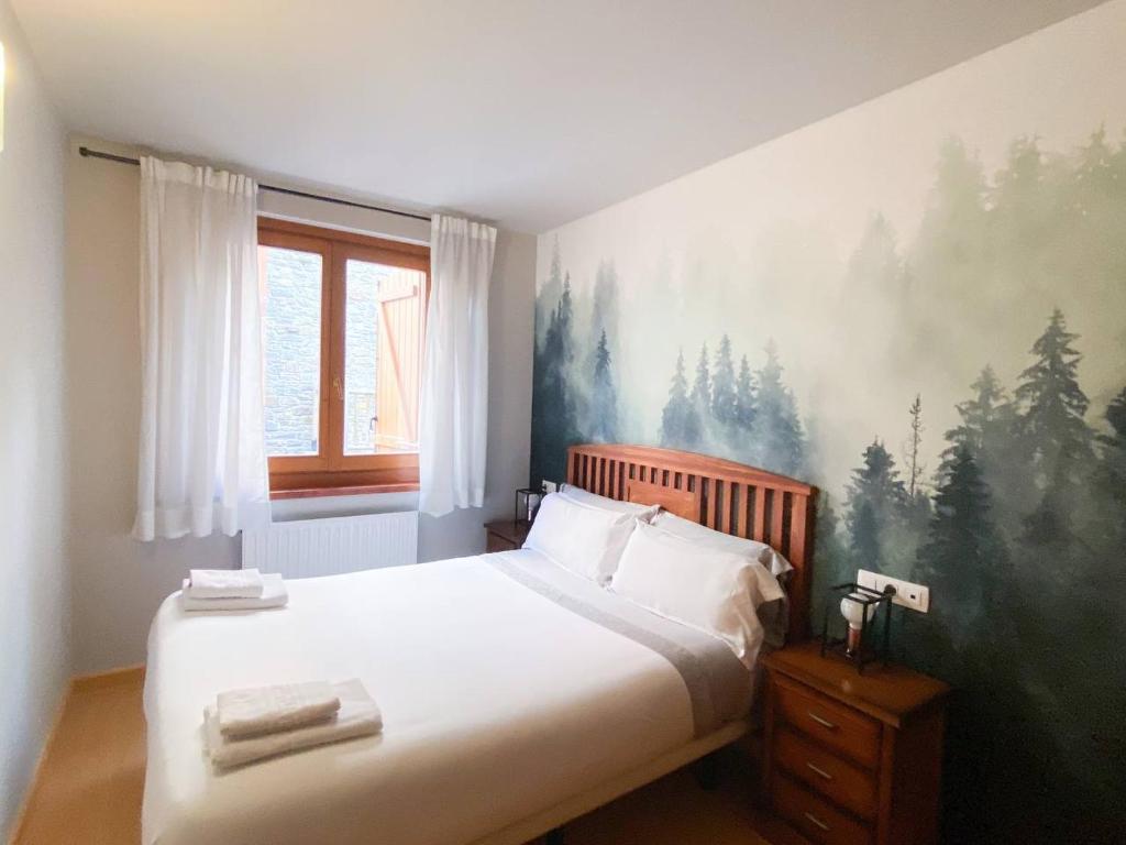1 dormitorio con 1 cama y una pintura en la pared en Soldeu nature - Parking Gratis - Disfruta En Familia, en Canillo