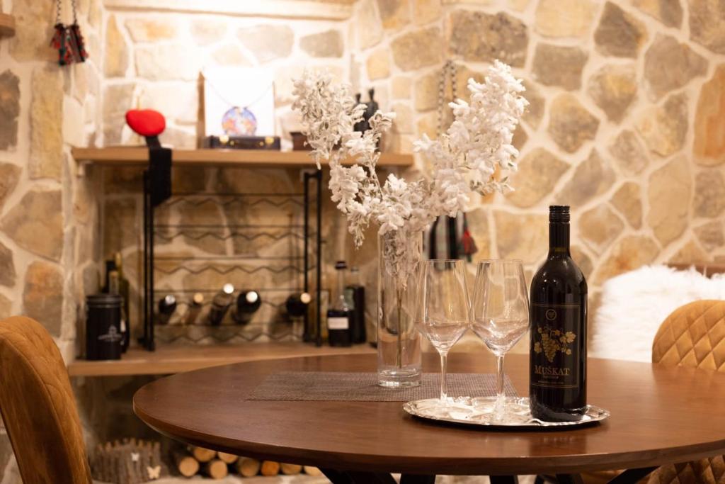 Madona di Sinj في سيني: طاولة مع زجاجة من النبيذ وكؤوس النبيذ