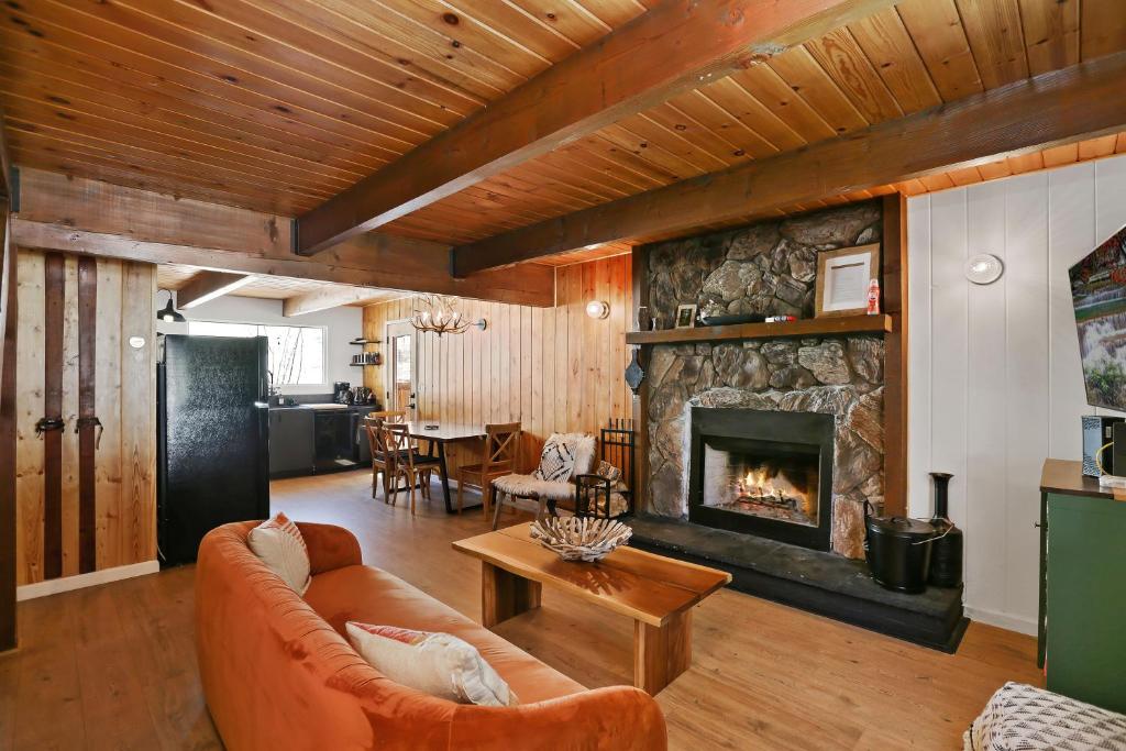 ein Wohnzimmer mit einem Sofa und einem Kamin in der Unterkunft Le Chalet of Arrowbear Lake in Running Springs