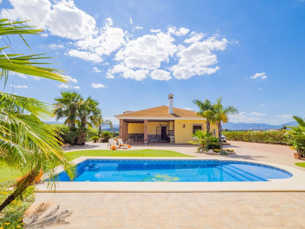 a villa with a swimming pool in front of a house at Cubo's Casa El Jazmin High Privacy in Alhaurín el Grande