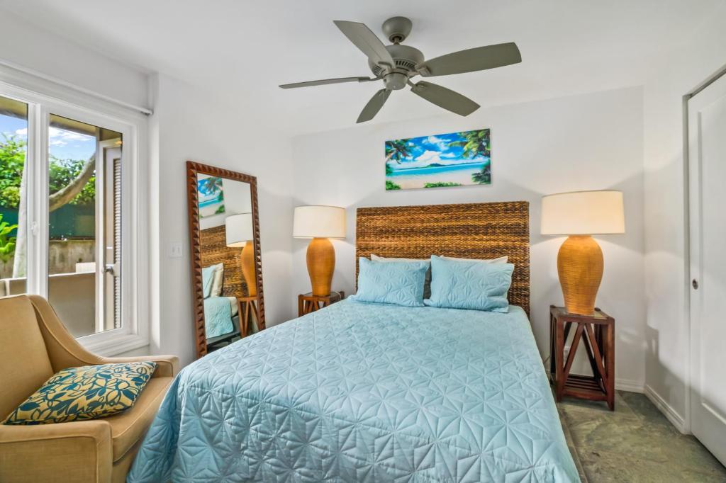 um quarto com uma cama e uma ventoinha de tecto em 2Br Kauai Kailani Condo, Pool, walk to Ocean & Shops, AC KK117 em Kapaa