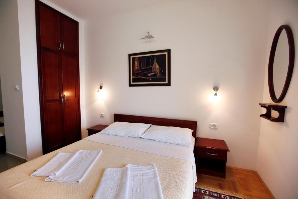 a bedroom with a bed with two towels on it at Apartments Baron in Sveti Stefan