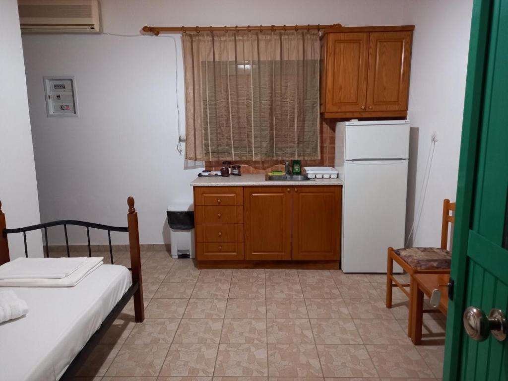 a small kitchen with a refrigerator and a table at Verde e Mare apartments-Marathias in Marathiás