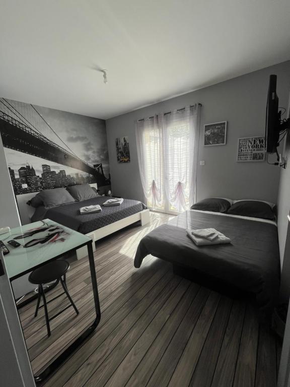 1 dormitorio con 2 camas, mesa y escritorio en Chambres d'Hôtes chez Estelle en Crêches-sur-Saône