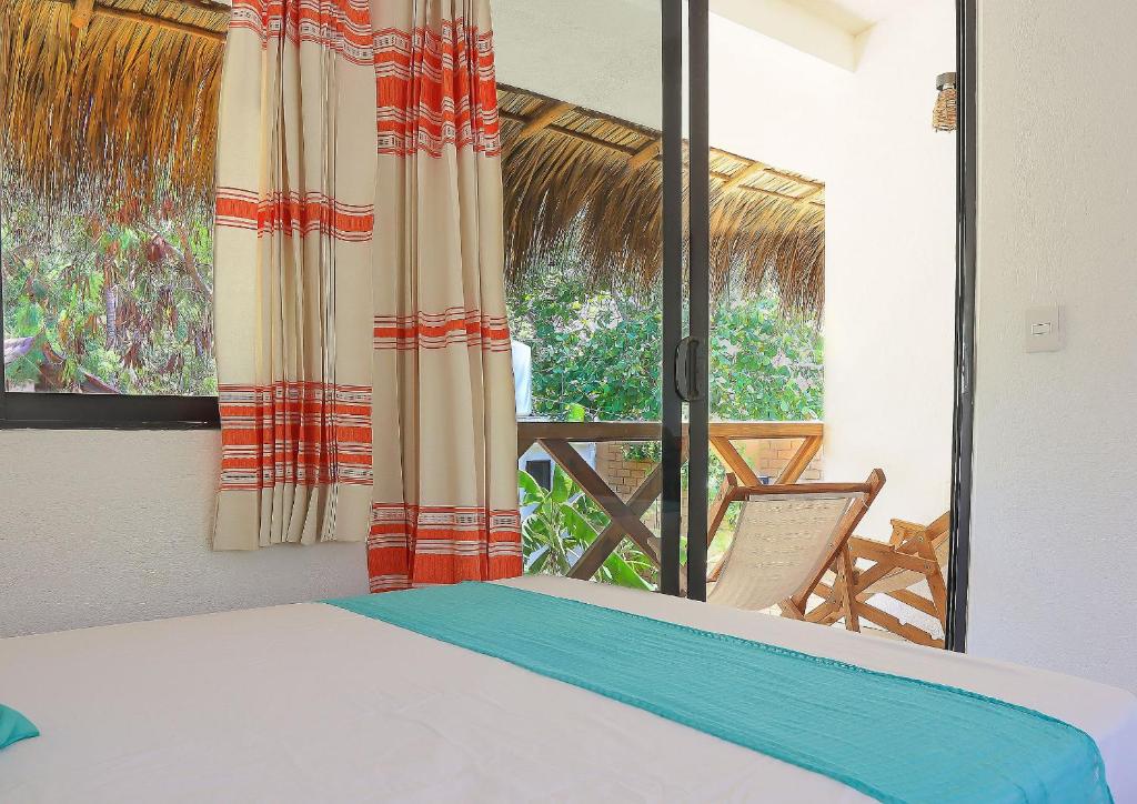 a bedroom with a bed and a view of a porch at Casa Yoo Bigu Mazunte in Mazunte