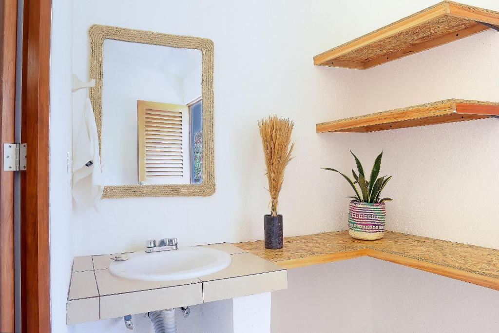 a bathroom with a sink and a mirror at Casa Yoo Bigu Mazunte in Mazunte
