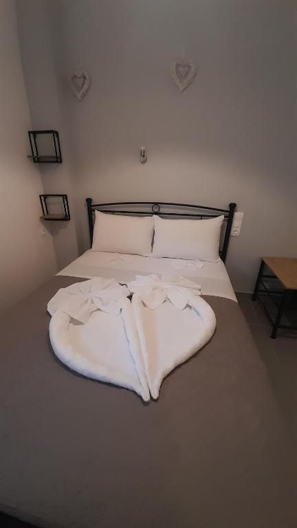 a bed with white sheets and pillows on it at Sweet Home in Rethymno