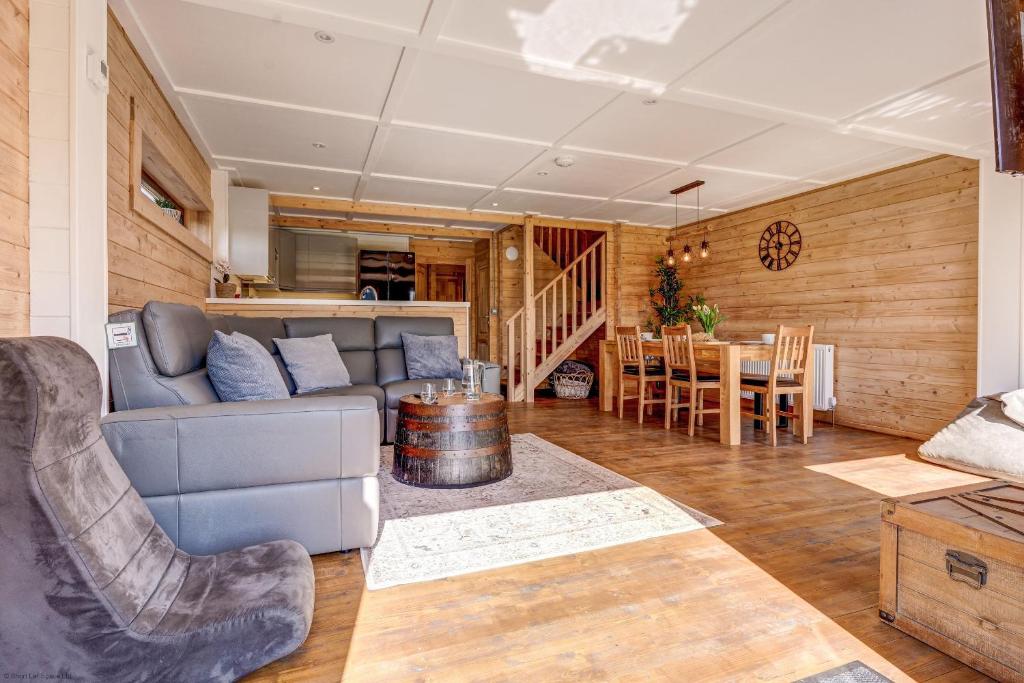 ein Wohnzimmer mit einem Sofa und einem Tisch in der Unterkunft Bluebell Lodge in Benson