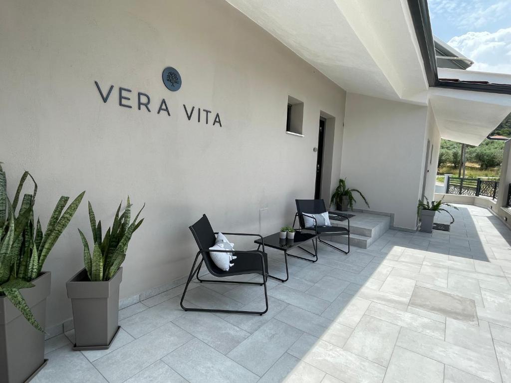 une chambre avec des chaises, des plantes et un panneau sur le mur dans l'établissement VERA VITA APARTMENTS, à Skala Rachoniou