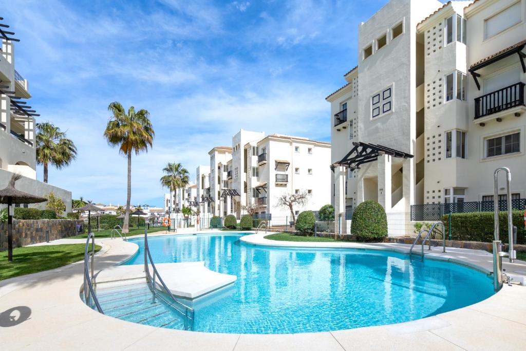 - une piscine en face de certains immeubles dans l'établissement 18 Nice apt balcony pool view close to Duquesa Golf and Beach Manilva Andalusia, à San Luis de Sabinillas