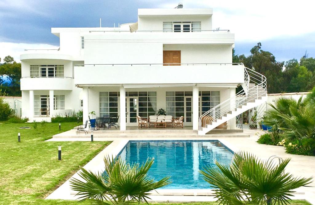 a white house with a swimming pool in front of it at Casa Deco Hotel Boutique in Cochabamba
