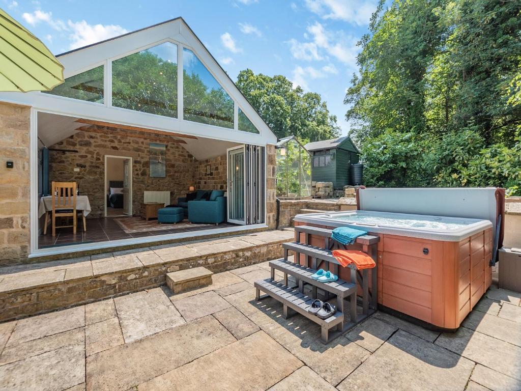 a backyard with a hot tub and a jacuzzi at Church Cottage in Two Dales