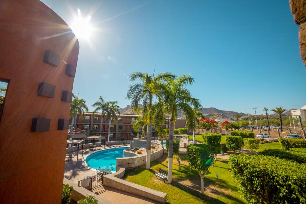 - une vue sur un complexe avec une piscine et des palmiers dans l'établissement Hotel Colonial Hermosillo, à Hermosillo