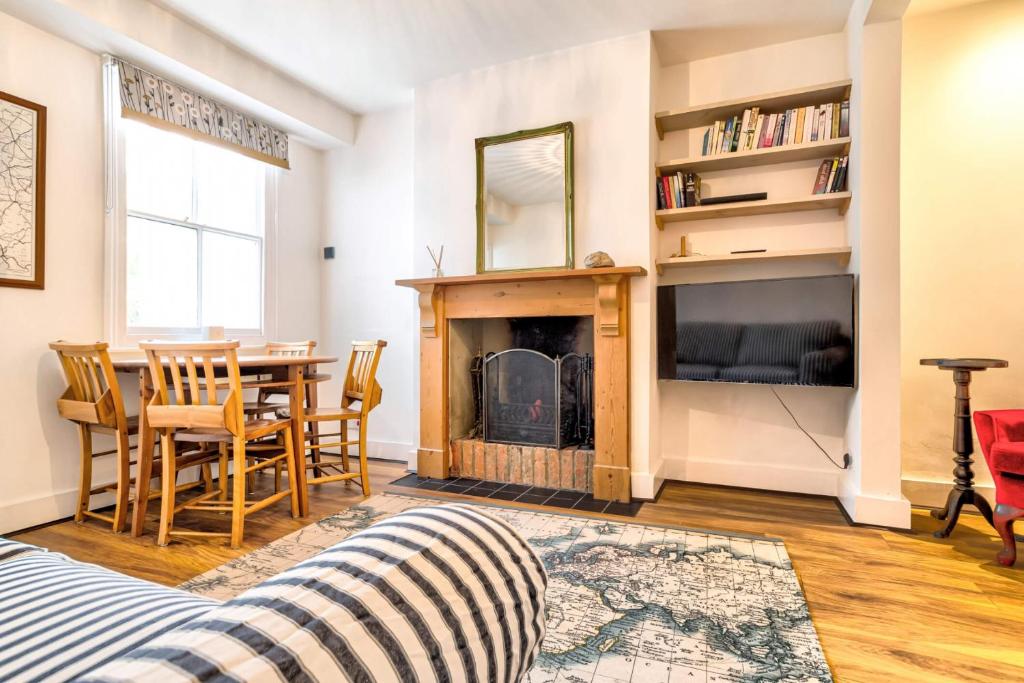 a living room with a fireplace and a table and chairs at Upper Fisher Row in Oxford